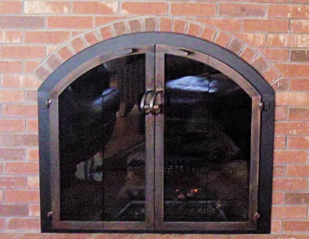 Osterville arch      Black frame, architectural bronze finish vice bi fold doors with forged center handles and  smoked glass.  No mesh, no draft panel.